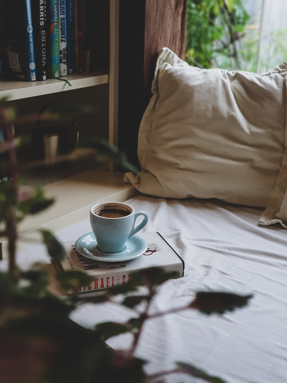 a cup of coffee on a book near a pillow